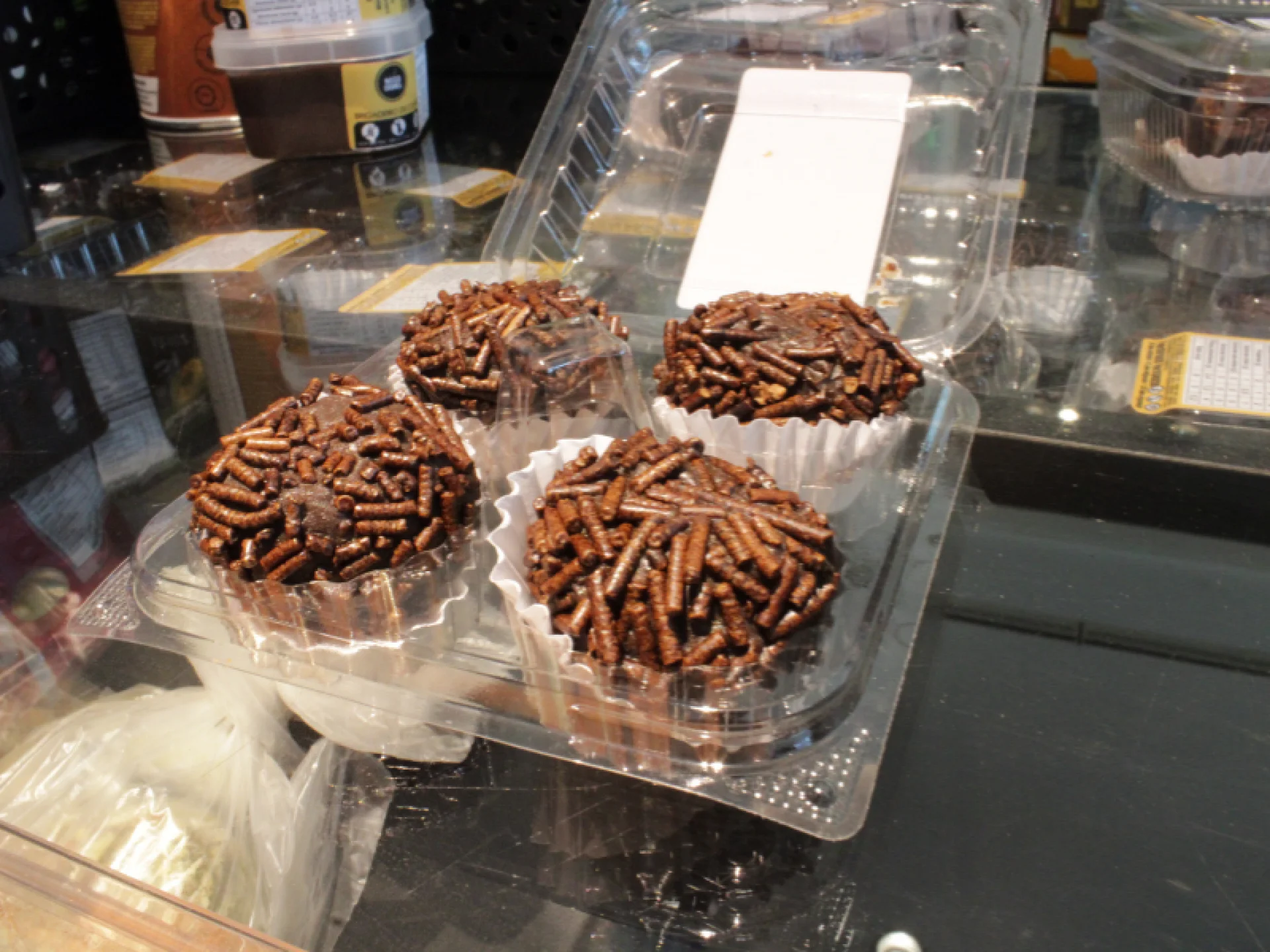 A imagem mostra uma embalagem com quatro brigadeiros saudáveis. A imagem mostra uma embalagem com quatro brigadeiros saudáveis.