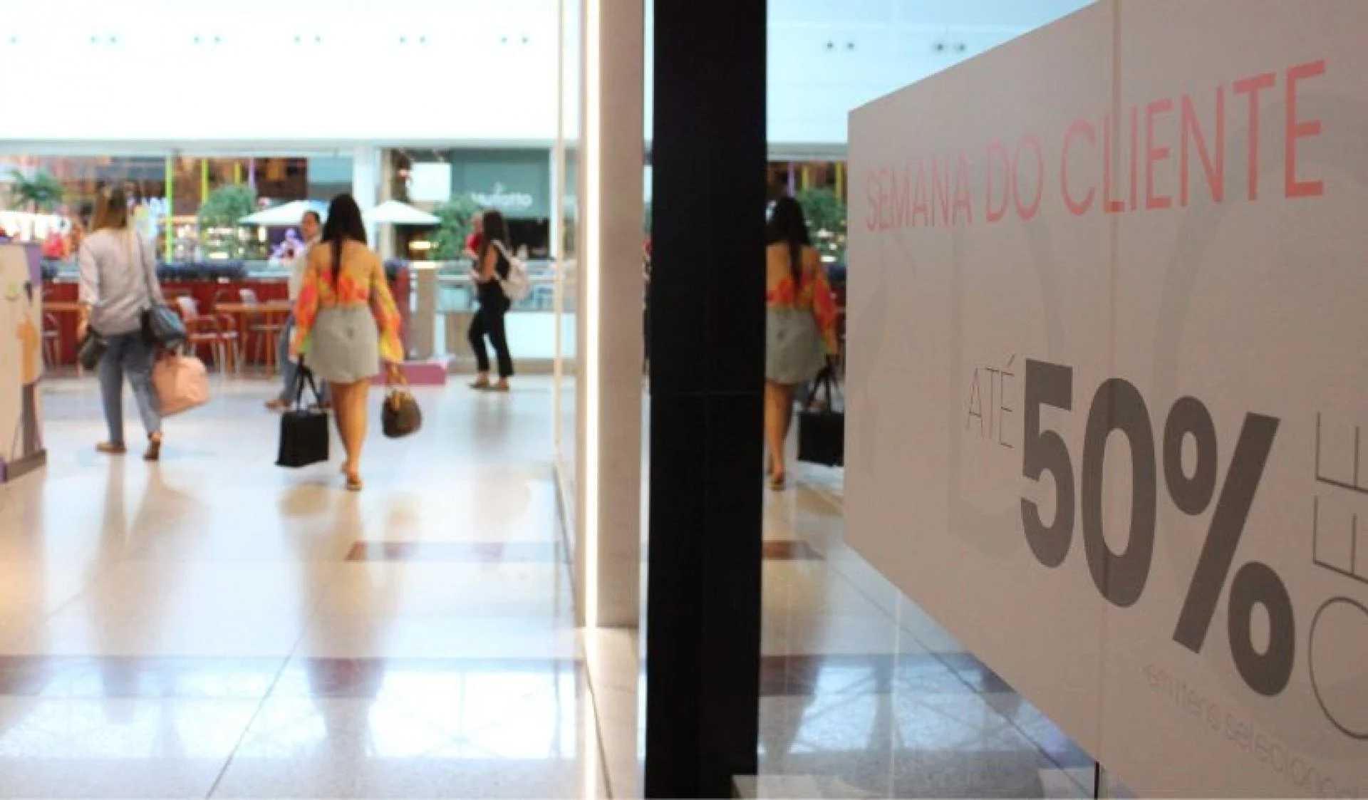Corredor do RioMar Recife com uma vitrine &agrave; direita escrito "Semana do Cliente at&eacute; 50%".