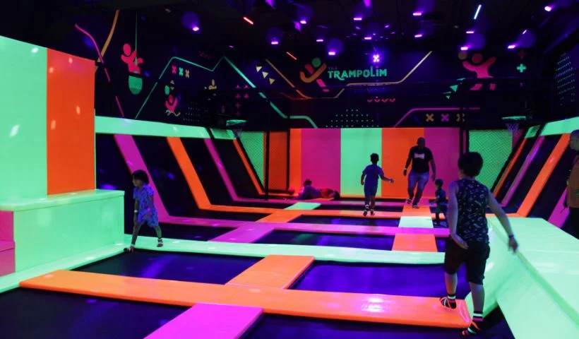 Imagem mostra espa&ccedil;o do Vila Trampolim com cores laranja, rosa e verde neon